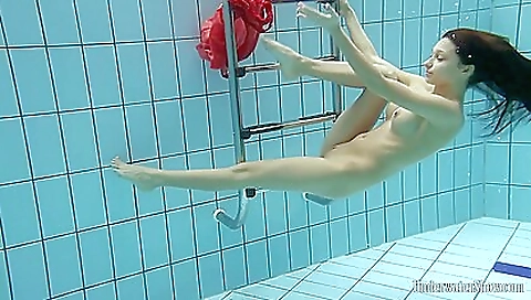 Sexy brunette in the pool enjoying the sun on the beach