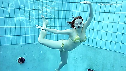 Slim brunette babe in the ocean with her tits exposed