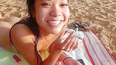 Nympho is a beach goddess who enjoys smoking in her nude bikini